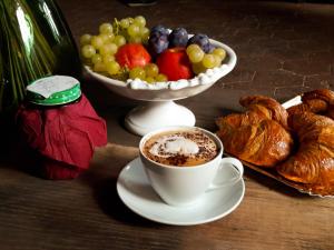 a table with a cup of coffee and a bowl of fruit at Agriturismo Villa Gorgognano in Certaldo