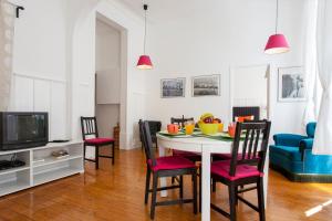 ein Wohnzimmer mit einem Tisch mit Stühlen und einem TV in der Unterkunft Downtown Augusta Apartment in Lissabon