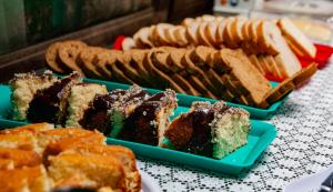 a table topped with different types of bread and desserts at Pousada Favo De Mel in Ilha do Mel