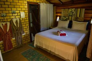 a bedroom with a bed with a stuffed animal on it at Pousada Favo De Mel in Ilha do Mel