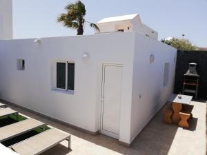 biały budynek z drzwiami na patio w obiekcie Love for Lanzarote holidays house w mieście Playa Blanca
