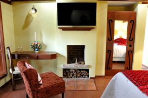 1 dormitorio con chimenea, 1 cama y TV en Casa Santa Lucia, en San Cristóbal de Las Casas
