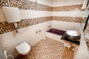 a bathroom with a toilet and a sink and a tub at Hotel Bhakti Rajkot I Hotel in Rajkot I Best Hotel in Rajkot in Rajkot +49 photos