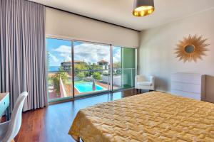 1 dormitorio con cama y ventana grande en Luxury Villa Nogueira with private pool by HR Madeira en Funchal