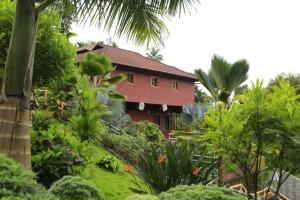 ein rotes Haus inmitten eines Gartens in der Unterkunft Jet Paark in Sultan Bathery