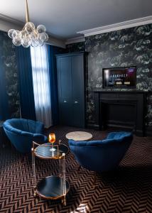 a living room with blue chairs and a fireplace at Lock and Key Boutique Hotel - Duke Street in Liverpool