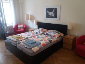 een slaapkamer met een bed en een rode stoel bij Geräumige zentrumsnahe Altbauwohnung in Wenen