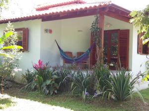 ein Haus mit einer Hängematte davor in der Unterkunft Bangalôs Parque Verde in Paraty