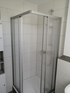 een douche met een glazen deur in de badkamer bij Apartment Central in Ratingen