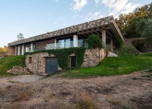 a house on top of a grassy hill at Vivienda Rural Olivar del Chanza in Cortegana