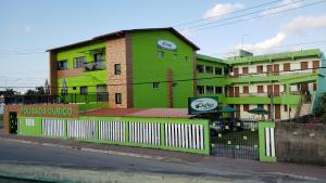 a green building on the side of a street at Pousada Ouriço in Porto De Galinhas