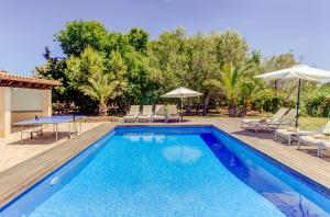 a pool with chairs and umbrellas in a yard at Villa Ponent by Sealand Villas in Pollença