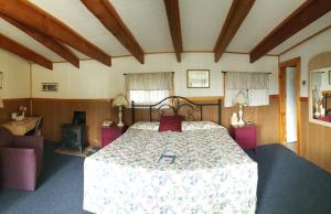 a hotel room with a bed, table and chairs at Twilite Motel in Ellsworth