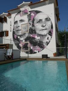 um mural na lateral de um edifício com piscina em Casa do Joaquim da Praia na Nazaré