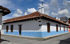 a small white and blue building with a roof at Casa Santa Lucia in San Cristóbal de Las Casas