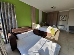 a hotel room with two beds and a couch at Green Side accommodation in Rustenburg