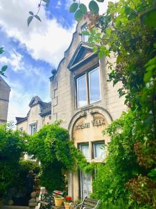 a building with a sign on the front of it at Lauras Townhouse Apartments Balloon Watchers Retreat in Bath