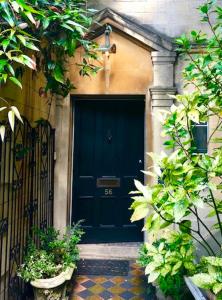 a black front door of a house with plants at Lauras Townhouse Apartments Balloon Watchers Retreat in Bath