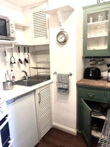 uma cozinha com armários verdes e um lavatório em Lauras Townhouse Apartments Balloon Watchers Retreat em Bath