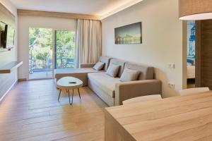 - un salon avec un canapé et une table dans l'établissement Sol Bahía Ibiza Suites, à Sant Antoni de Portmany