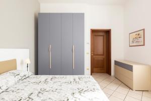 a bedroom with a bed and a cabinet and a door at CASA ANNALIA in Piacenza