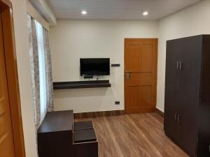 a room with a flat screen tv and a door at Denzong Khim in Gangtok