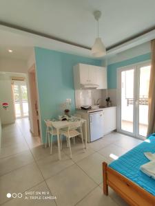 a kitchen and dining room with a table and a kitchen and a room at Kostas Apartments in Stalís