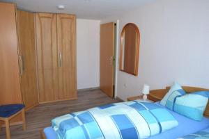 a bedroom with a blue bed and a wooden cabinet at Apartment Baden Baden Haus am Ibachweg in Baden-Baden