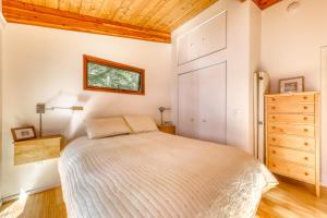 a bedroom with a bed and a wooden ceiling at Lily Pond Bungalow in Edgecomb