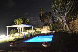 a swimming pool in a yard at night at Villa Sciammaca in Brucoli