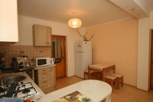 a kitchen with a white refrigerator and a table at Гостьовий дім Tauer in Tatariv