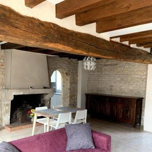 uma sala de estar com uma mesa e uma lareira em cœur de village em La Chapelle-Onzerain