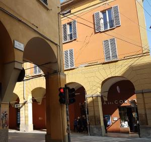 a building with arches and a traffic light on a street at Residenza Rialto in Bologna