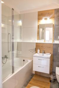a bathroom with a tub and a sink and a shower at Apartament Yooka in Szczecin