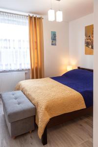 a bedroom with a large bed and a window at Apartament Yooka in Szczecin