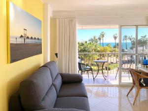 sala de estar con sofá y vistas al océano en El Nido, en Torre del Mar