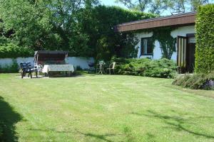 a yard with a table and chairs and a house at Guest cottege in Ystad