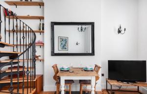 a dining room with a table and a tv and a mirror at Warwick Post Office Apartment in Warwick