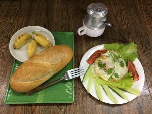 a plate of food with a sandwich and a plate of bread at Homestay Xóm Dừa Nước in Ben Tre