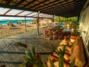 a deck with a table and chairs on the beach at Buzios Espiritualidade Hotel in Búzios