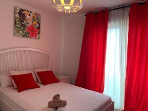 a bedroom with red curtains and a bed with a stuffed animal on it at Apartamento Las Terrazas in Granadilla de Abona +33 photos