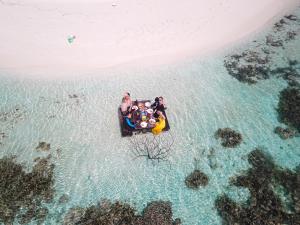 Un gruppo di persone su una zattera nell'oceano di Nemo Inn a Omadhoo