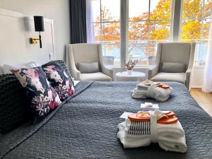a bedroom with a large bed with towels and chairs at Gränsö Slott Hotel & Spa in Västervik