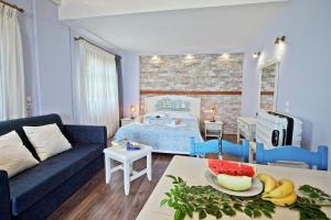 sala de estar con sofá azul y dormitorio en Flamingo Hotel Pelion - Seaside Superior Studios & Suites, en Khorevtón