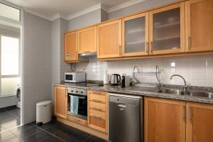 a kitchen with wooden cabinets and stainless steel appliances at Peace Haven ll in Calheta