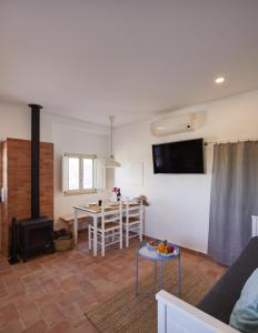 a living room with a stove and a dining room at Moinho do Barulho in São Bartolomeu de Messines