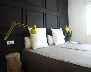 1 dormitorio con 1 cama con lámpara amarilla y almohadas blancas en APARTAMENTO BEDANDBEACH, en El Palmar