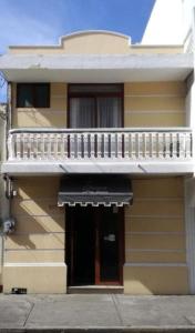 un edificio amarillo con balcón y puerta en Hotel Posada San Juan, en Veracruz