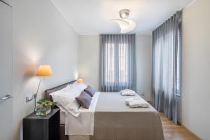 a white bedroom with a bed and a window at 30Cavour luxury suites in Pavia
