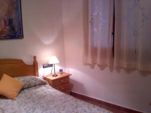 a bedroom with a bed and a lamp on a night stand at CA MARTÍN 2 in Benifallet